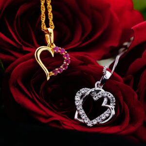 Silver and gold decorative hearts with small gems placed on bud of red rose
