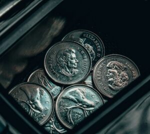 silver round coin on black surface
